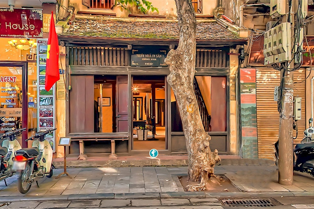 The house features wooden beams, tiled roofs, and an open courtyard, reflecting classic Vietnamese design